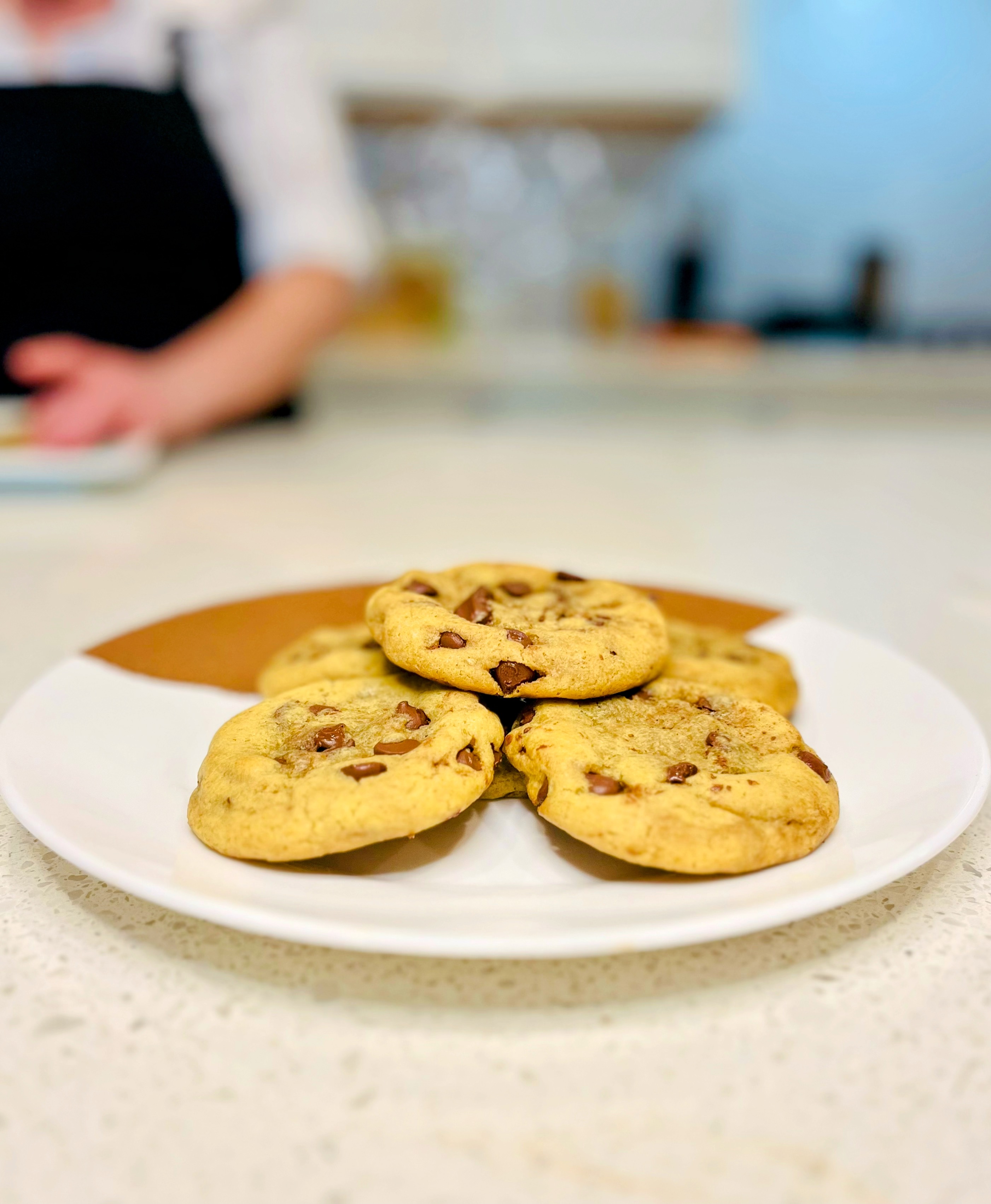 Fresh-baked chocolate chip cookies plated on kitchen counter