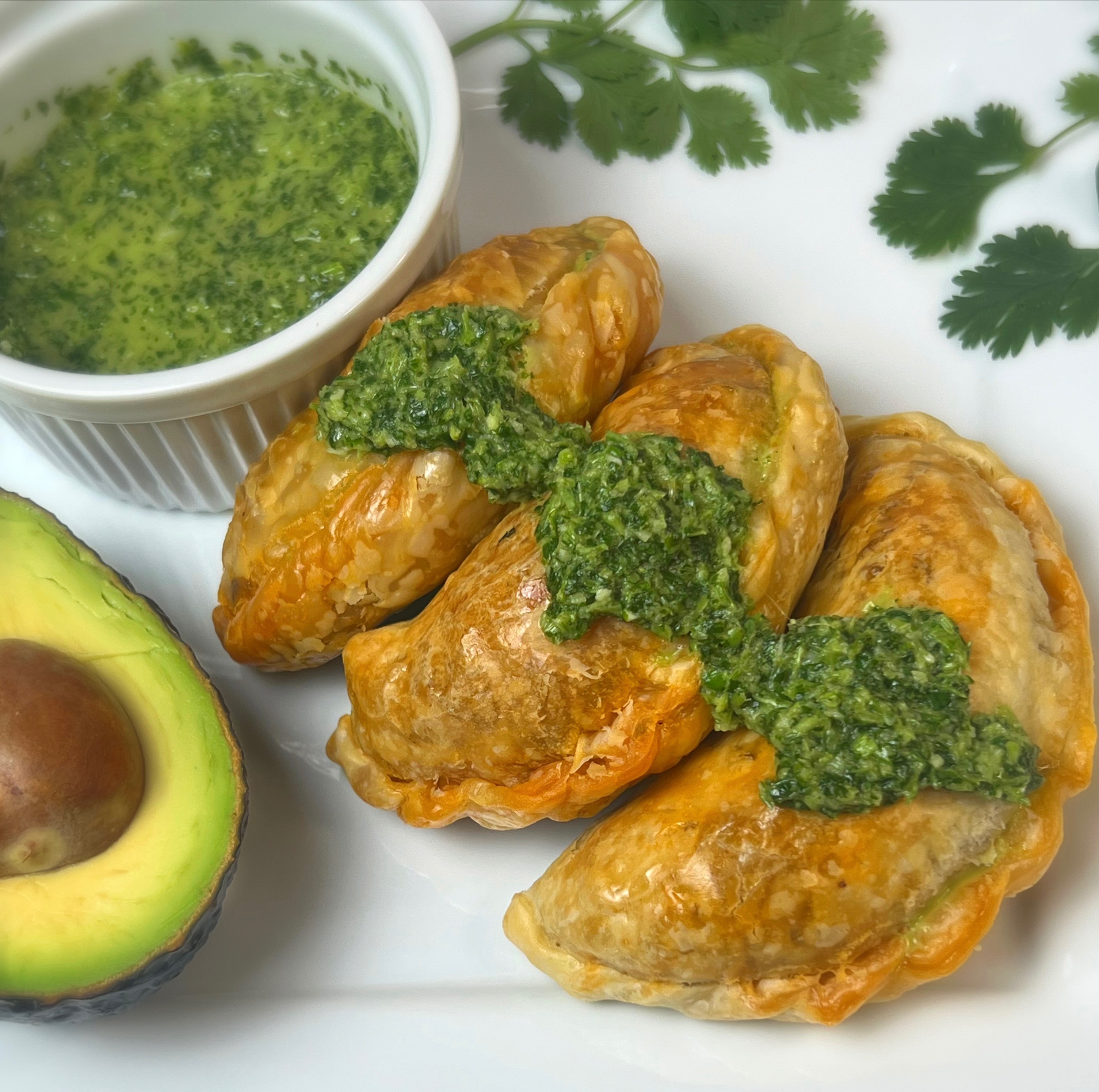 Golden baked empanadas with chimichurri and fresh avocado
