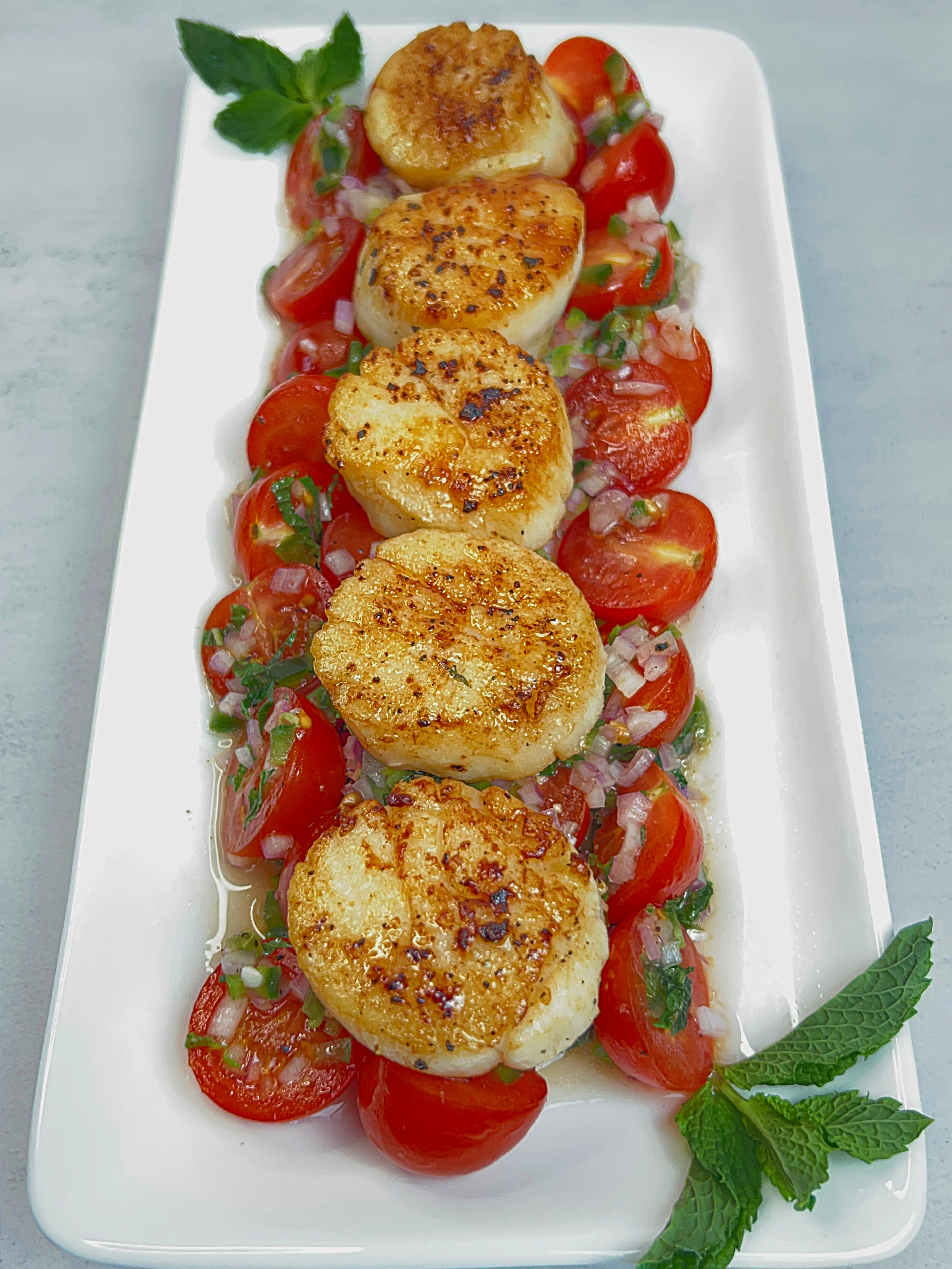 Seared scallop skewers over grilled asparagus with tomato vinaigrette